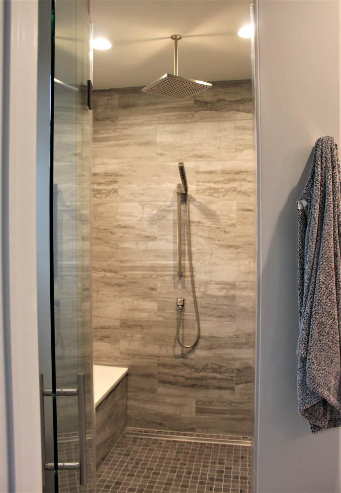 Photo of a mid-sized transitional bathroom in DC Metro with a freestanding tub, ceramic floors, a sliding shower screen and a shower seat.