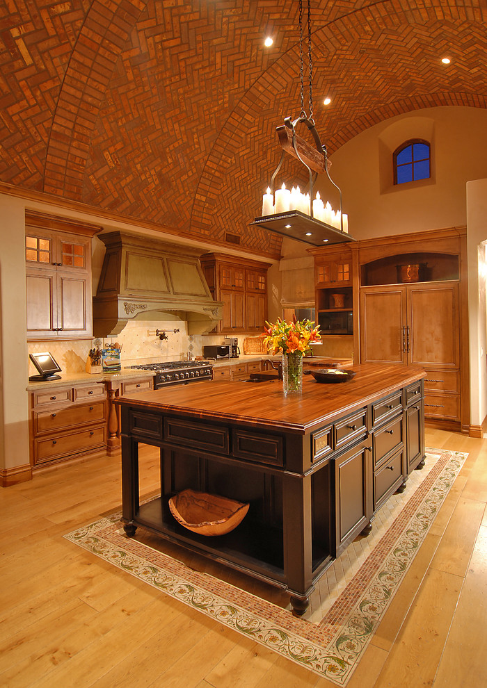 Mediterranean kitchen in Phoenix with wood benchtops.