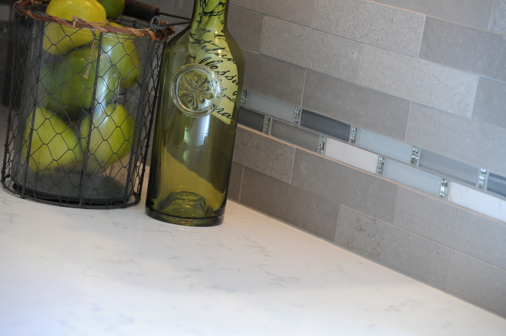 Eat-in kitchen - mid-sized l-shaped dark wood floor eat-in kitchen idea in Cincinnati with an undermount sink, shaker cabinets, quartz countertops, gray backsplash, stainless steel appliances, an island and subway tile backsplash