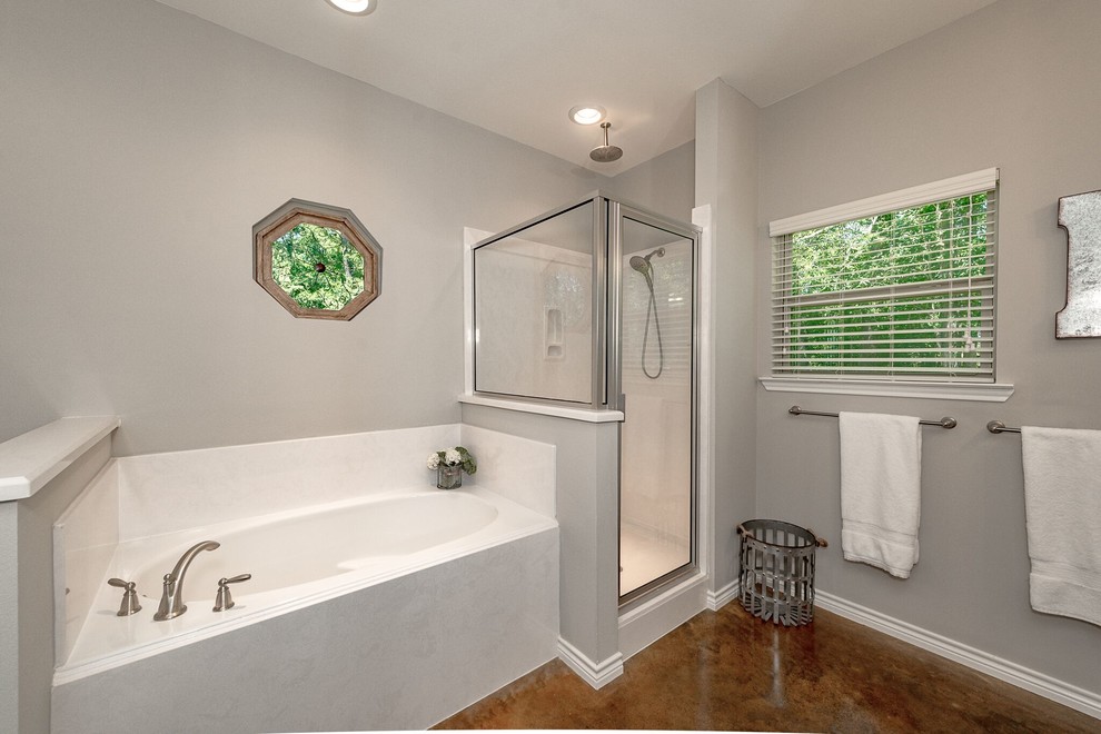 Photo of a mid-sized transitional master bathroom in Austin with shaker cabinets, white cabinets, a corner tub, an alcove shower, a two-piece toilet, white tile, subway tile, grey walls, concrete floors, a pedestal sink, solid surface benchtops, brown floor and a hinged shower door.