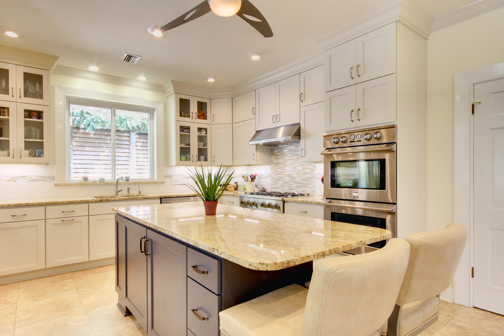 Inspiration for a mid-sized transitional u-shaped vinyl floor eat-in kitchen remodel in Miami with an undermount sink, shaker cabinets, white cabinets, granite countertops, white backsplash, subway tile backsplash, stainless steel appliances and an island