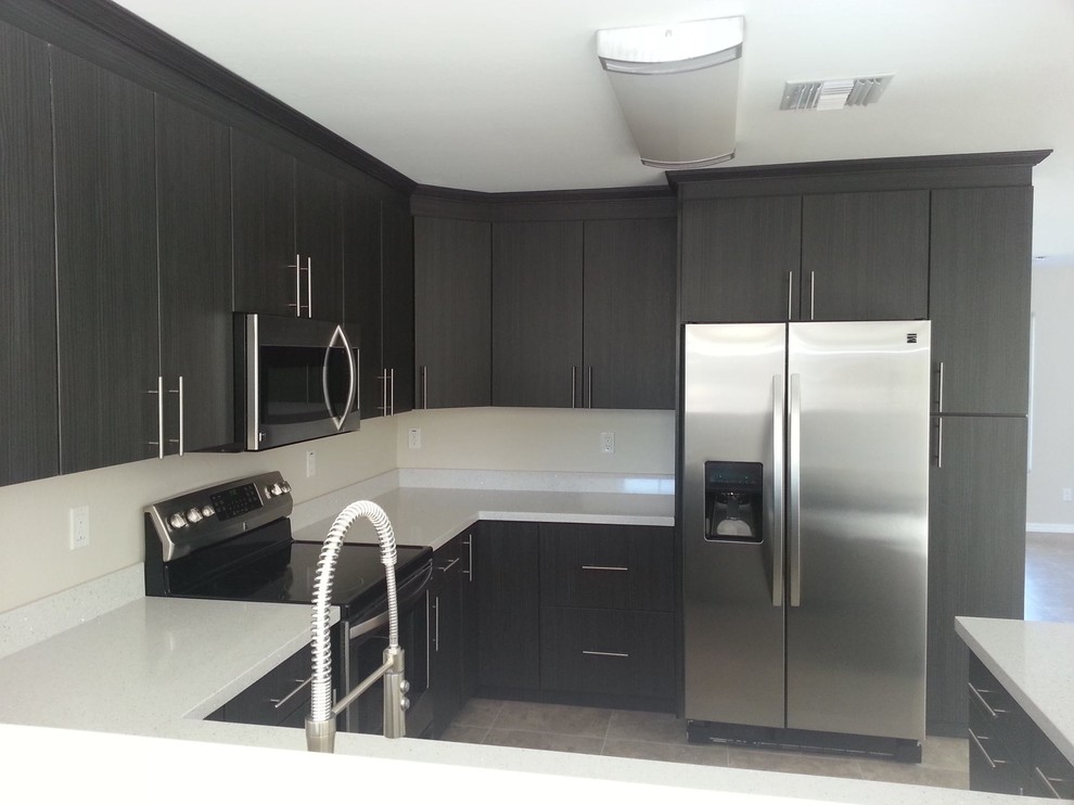 Photo of a large l-shaped kitchen pantry in Phoenix with a drop-in sink, flat-panel cabinets, grey cabinets, white splashback, glass tile splashback, stainless steel appliances, medium hardwood floors, with island and recycled glass benchtops.