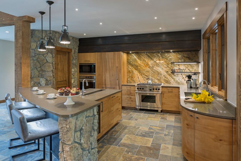 This is an example of a large country u-shaped eat-in kitchen in Denver with a double-bowl sink, flat-panel cabinets, medium wood cabinets, solid surface benchtops, beige splashback, stone slab splashback, stainless steel appliances, ceramic floors and with island.