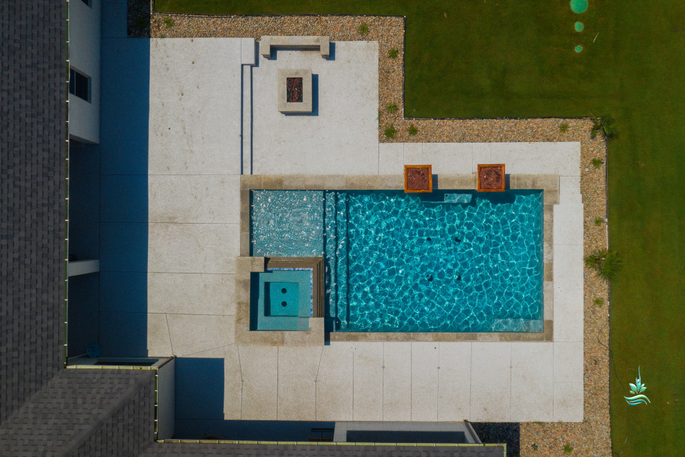 Ispirazione per un'ampia piscina naturale minimalista rettangolare dietro casa con pedane