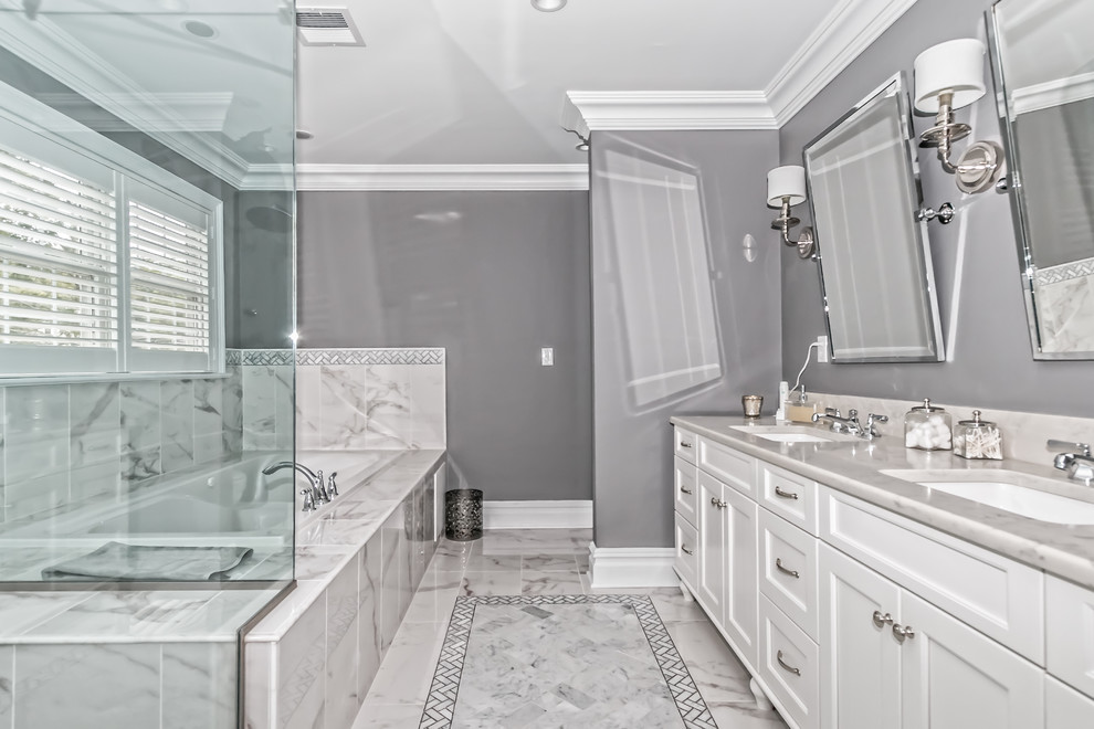 Large modern master bathroom in New York with recessed-panel cabinets, white cabinets, a drop-in tub, white tile, ceramic tile, grey walls, ceramic floors, an undermount sink and granite benchtops.