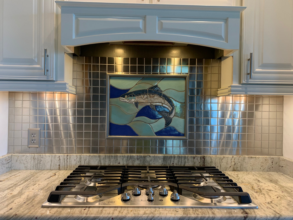 Eat-in kitchen - eat-in kitchen idea with raised-panel cabinets, gray cabinets, granite countertops, mosaic tile backsplash, stainless steel appliances, gray backsplash and white countertops