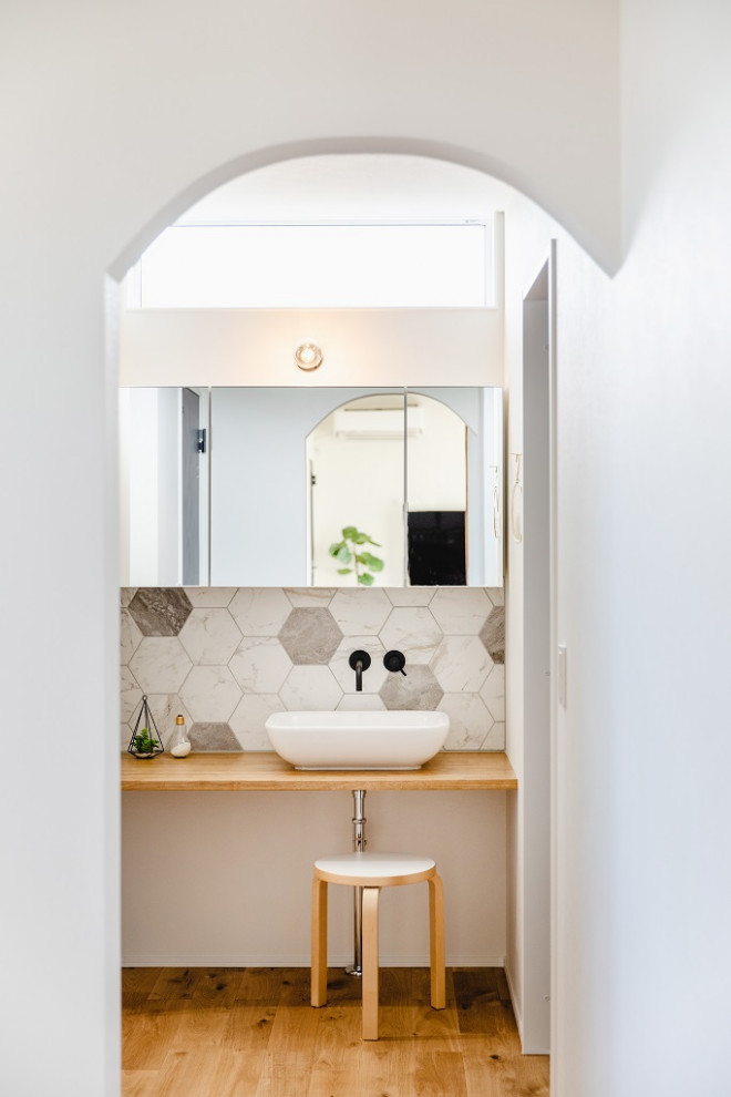 Inspiration för ett medelhavsstil beige beige toalett, med vita skåp, vita väggar och ljust trägolv