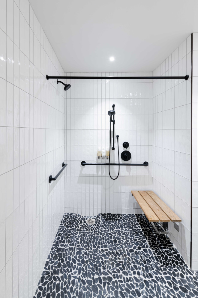 Immagine di una stanza da bagno padronale minimal di medie dimensioni con doccia doppia, piastrelle bianche, piastrelle in ceramica, pareti bianche, pavimento con piastrelle di ciottoli, pavimento nero, doccia aperta e panca da doccia