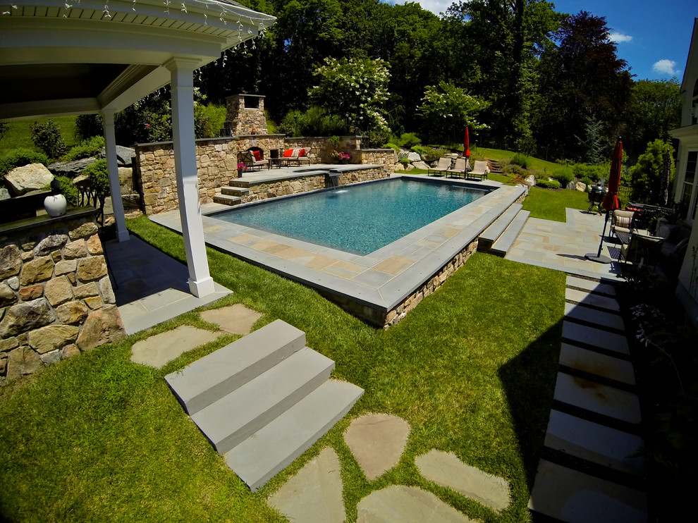 Photo of a large traditional backyard rectangular pool in Philadelphia with a hot tub and decking.