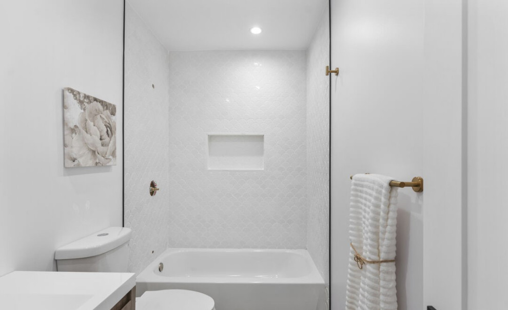 Cette image montre une salle d'eau design avec un placard à porte plane, des portes de placard marrons, une baignoire en alcôve, un combiné douche/baignoire, WC à poser, un carrelage blanc, des carreaux de céramique, un mur blanc, un sol en carrelage de céramique, un lavabo intégré, un plan de toilette en quartz, un sol blanc, une cabine de douche avec un rideau, un plan de toilette blanc, une niche, meuble simple vasque et meuble-lavabo encastré.
