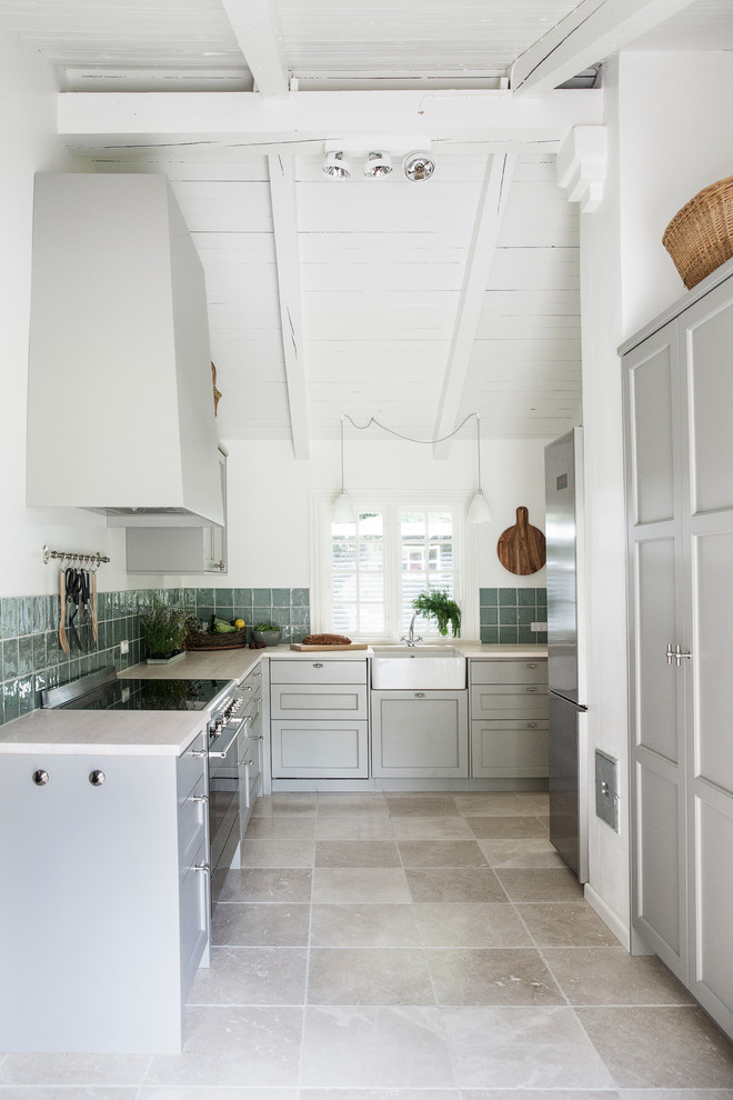 Design ideas for a mid-sized scandinavian l-shaped separate kitchen in London with a single-bowl sink, shaker cabinets, grey cabinets, porcelain splashback, stainless steel appliances, no island, grey floor and green splashback.