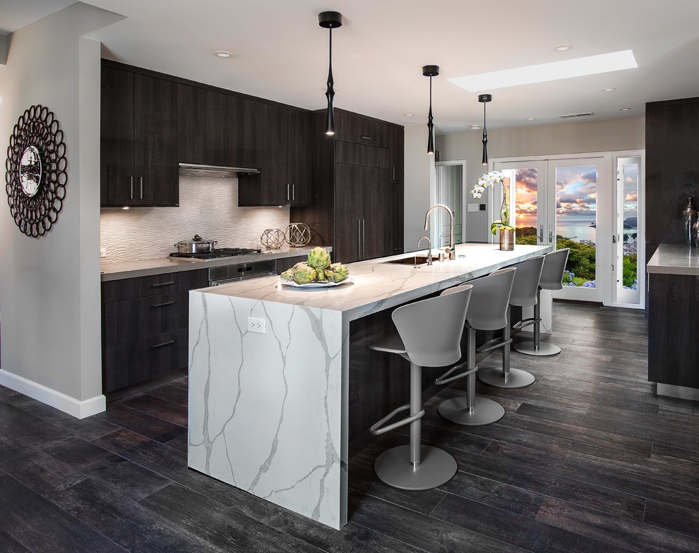 Photo of a mid-sized contemporary kitchen in Los Angeles with flat-panel cabinets, quartz benchtops, porcelain splashback, panelled appliances, with island, white benchtop, an undermount sink, dark wood cabinets, white splashback and dark hardwood floors.