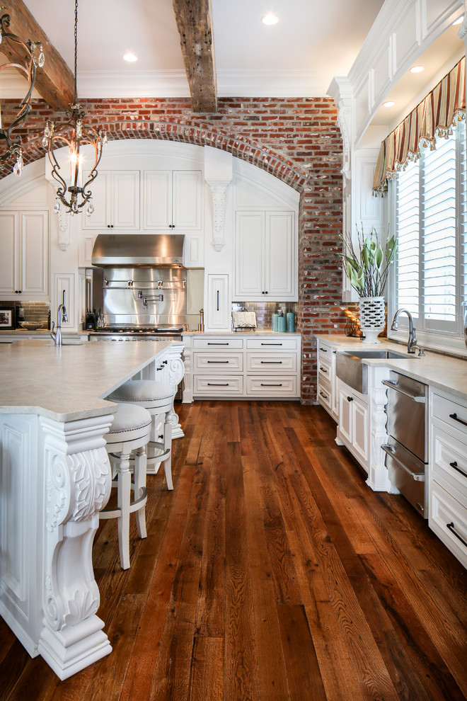Design ideas for an expansive traditional kitchen in New Orleans with an undermount sink, white cabinets, granite benchtops, grey splashback, subway tile splashback, stainless steel appliances, medium hardwood floors and with island.