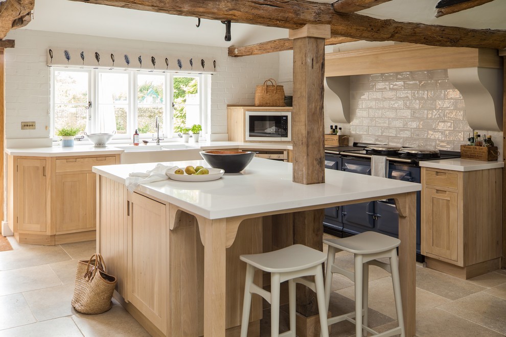 Inspiration for a country l-shaped kitchen in Other with a farmhouse sink, shaker cabinets, medium wood cabinets, white splashback, coloured appliances, with island, beige floor and white benchtop.