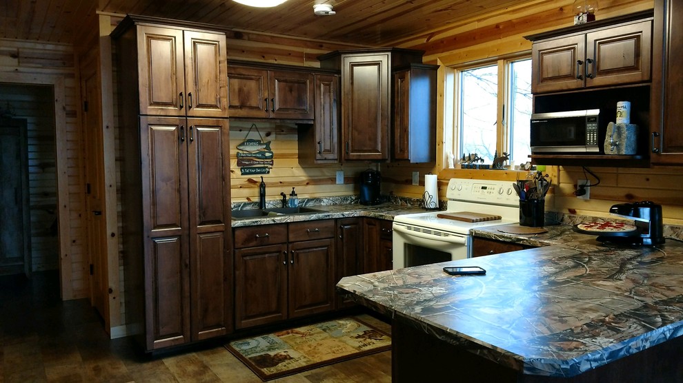 Example of a small classic u-shaped medium tone wood floor and brown floor enclosed kitchen design with raised-panel cabinets, a double-bowl sink, dark wood cabinets, brown backsplash, wood backsplash, white appliances, a peninsula and laminate countertops
