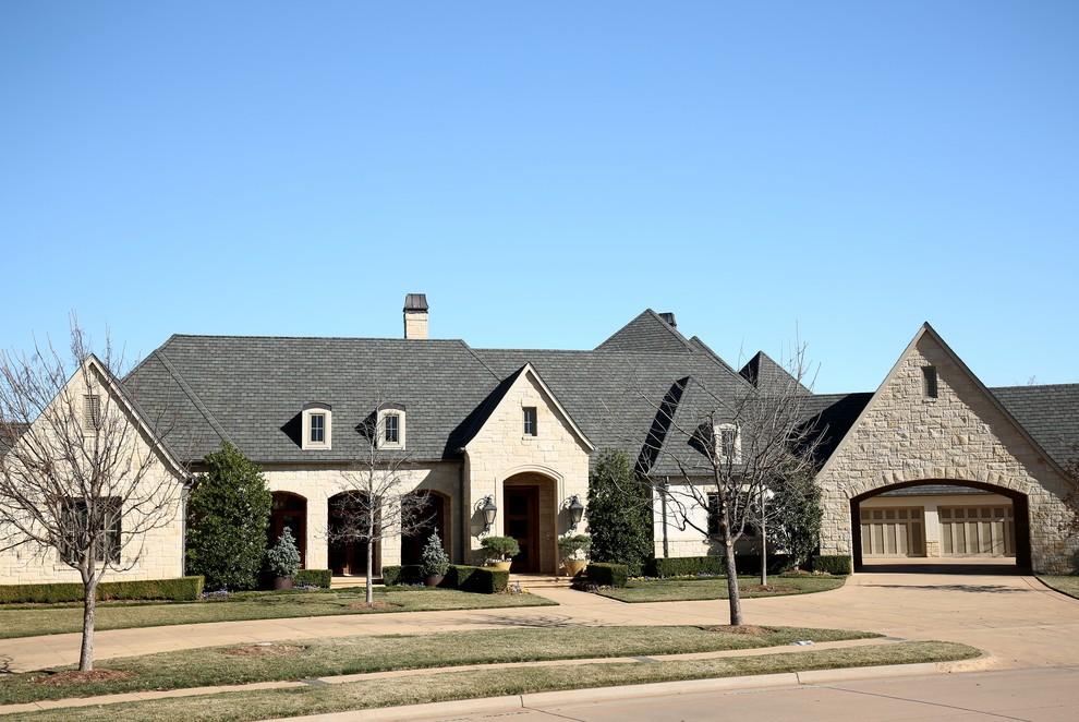 Inspiration for a large traditional two-storey beige exterior in Oklahoma City with mixed siding and a gable roof.