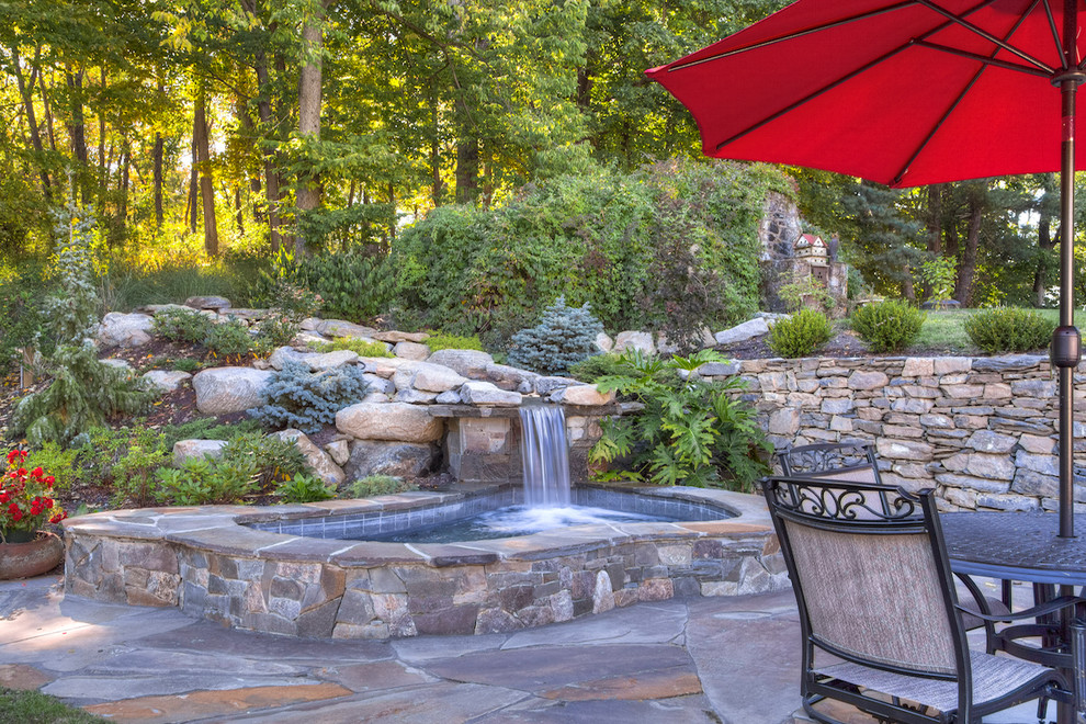Small traditional backyard kidney-shaped natural pool in New York with a hot tub and natural stone pavers.