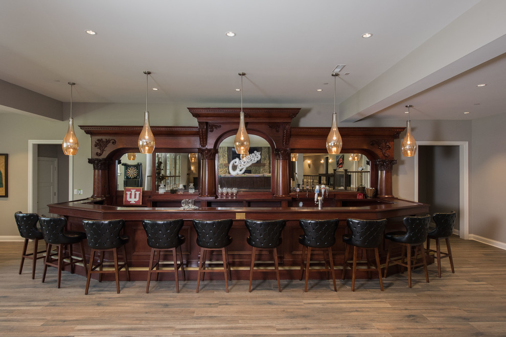 Design ideas for a large traditional galley seated home bar in Chicago with laminate floors, brown floor, open cabinets, medium wood cabinets, mirror splashback and brown benchtop.