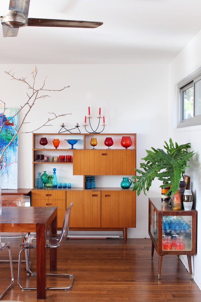 Mid-sized eclectic dining room in Sydney with white walls and medium hardwood floors.