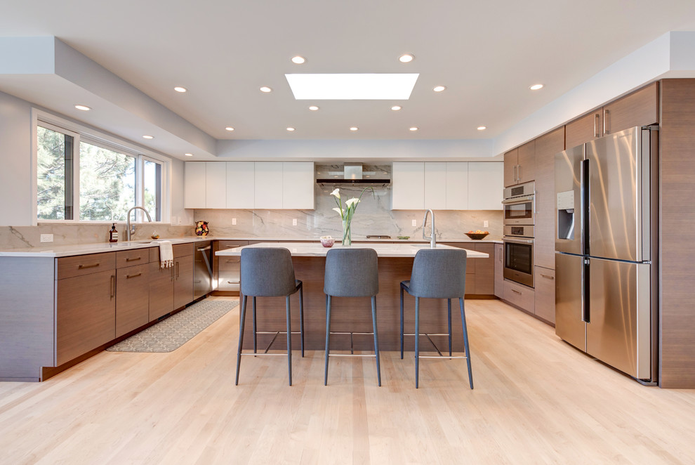 Inspiration for an expansive contemporary u-shaped kitchen in Denver with an undermount sink, flat-panel cabinets, dark wood cabinets, stainless steel appliances, light hardwood floors, with island and beige floor.