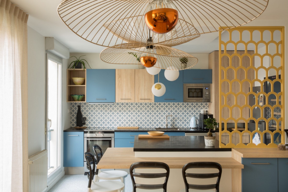 This is an example of a mid-sized scandinavian single-wall open plan kitchen in Lyon with an integrated sink, blue cabinets, cement tile splashback and with island.