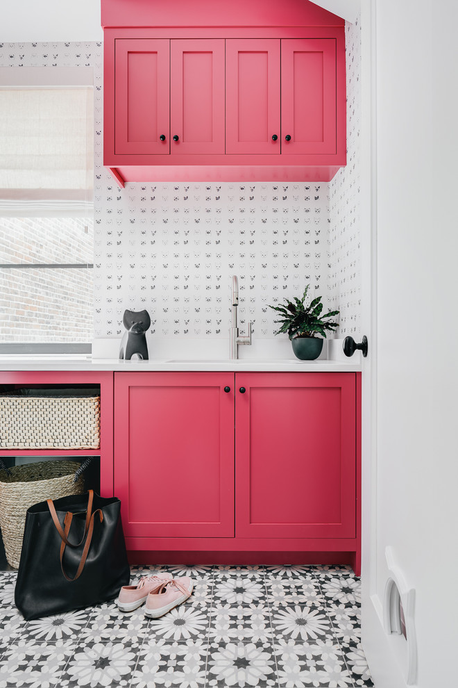 Inspiration for a transitional laundry room in San Francisco with an undermount sink, shaker cabinets, red cabinets, white walls, multi-coloured floor and white benchtop.