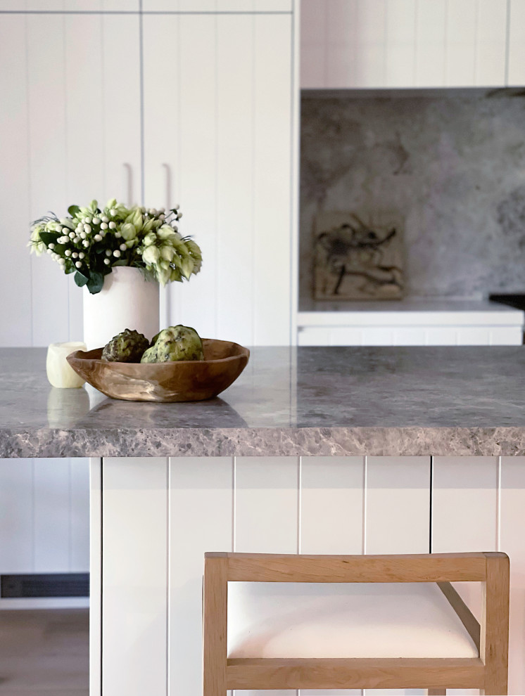 Immagine di una grande cucina contemporanea con ante bianche e top in pietra calcarea