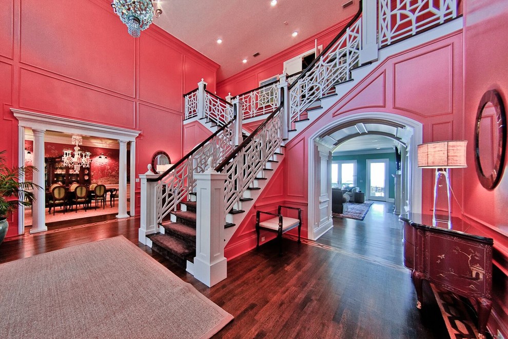 This is an example of an expansive traditional carpeted l-shaped staircase in Tampa with carpet risers and wood railing.
