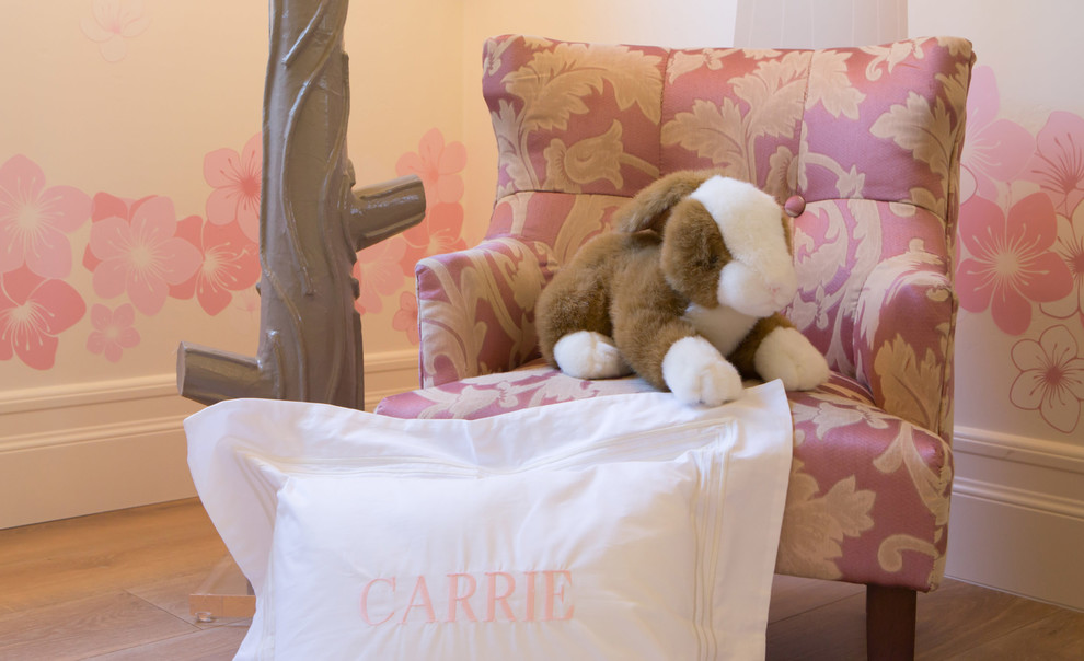 This is an example of a large traditional nursery for girls in San Diego with white walls and medium hardwood floors.