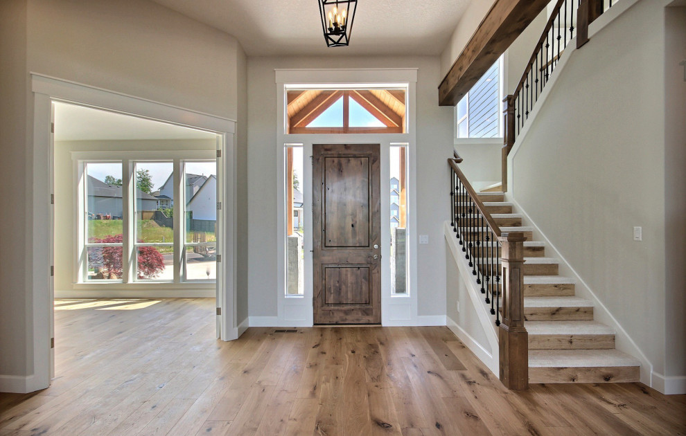 Design ideas for an expansive transitional foyer in Portland with beige walls, light hardwood floors, a single front door, a medium wood front door, brown floor and exposed beam.