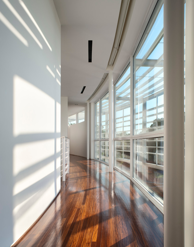 Photo of a contemporary hallway in Dallas with white walls and dark hardwood floors.