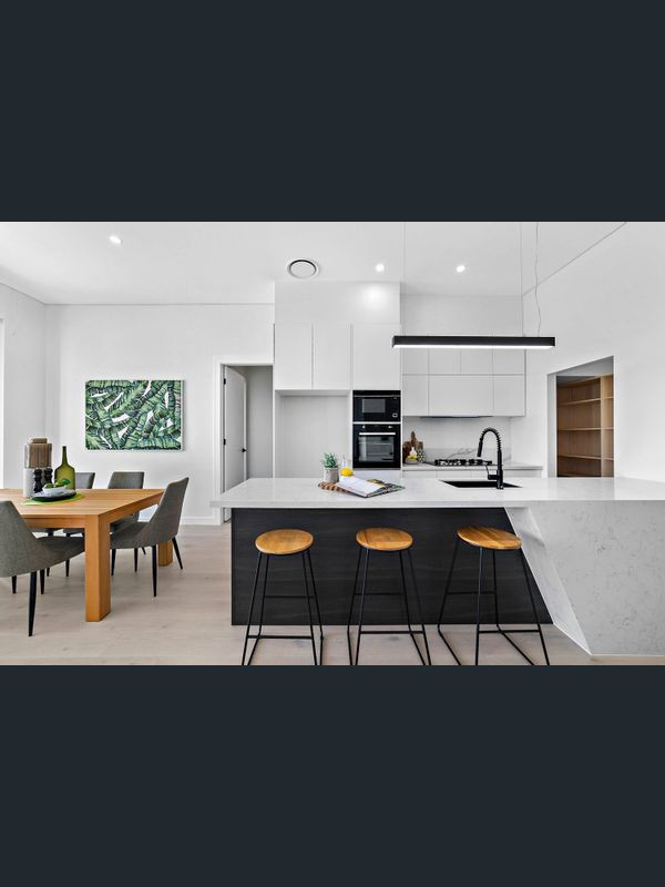 Bild på ett stort funkis flerfärgad flerfärgat kök, med en undermonterad diskho, marmorbänkskiva, vitt stänkskydd, stänkskydd i marmor, svarta vitvaror, plywoodgolv, en köksö och beiget golv