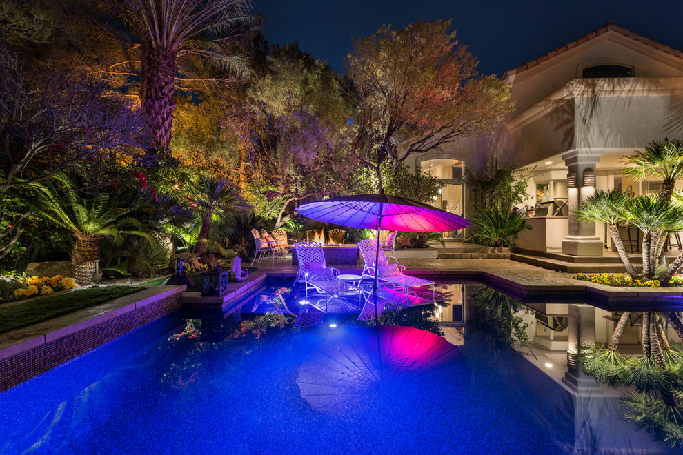 Inspiration for a large transitional backyard rectangular lap pool in Las Vegas with a water feature and decking.