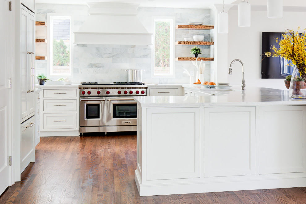 Example of a mid-sized transitional u-shaped medium tone wood floor and brown floor open concept kitchen design with a farmhouse sink, recessed-panel cabinets, white cabinets, quartz countertops, multicolored backsplash, marble backsplash, stainless steel appliances, a peninsula and white countertops