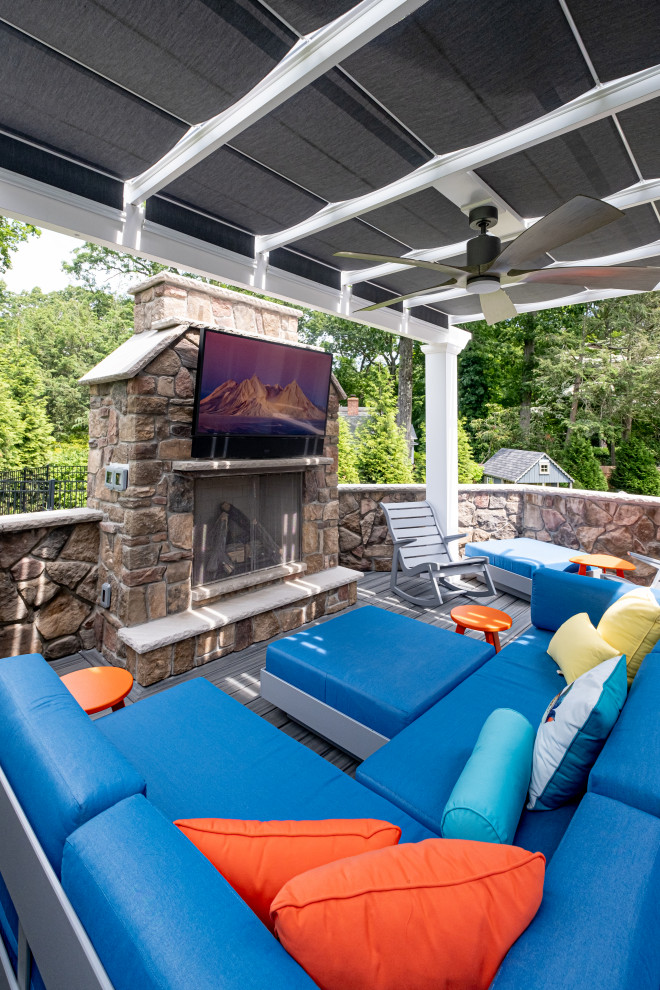 Mid-sized transitional backyard and ground level deck in New York with with fireplace and a pergola.