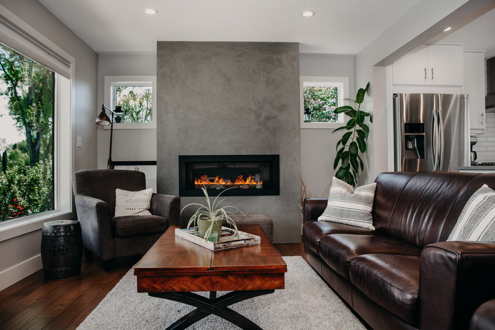 Inspiration for a mid-sized modern formal open concept living room in Edmonton with white walls, medium hardwood floors, a standard fireplace and brown floor.