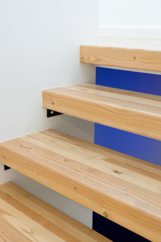 Photo of a small modern wood u-shaped staircase in Portland with open risers.