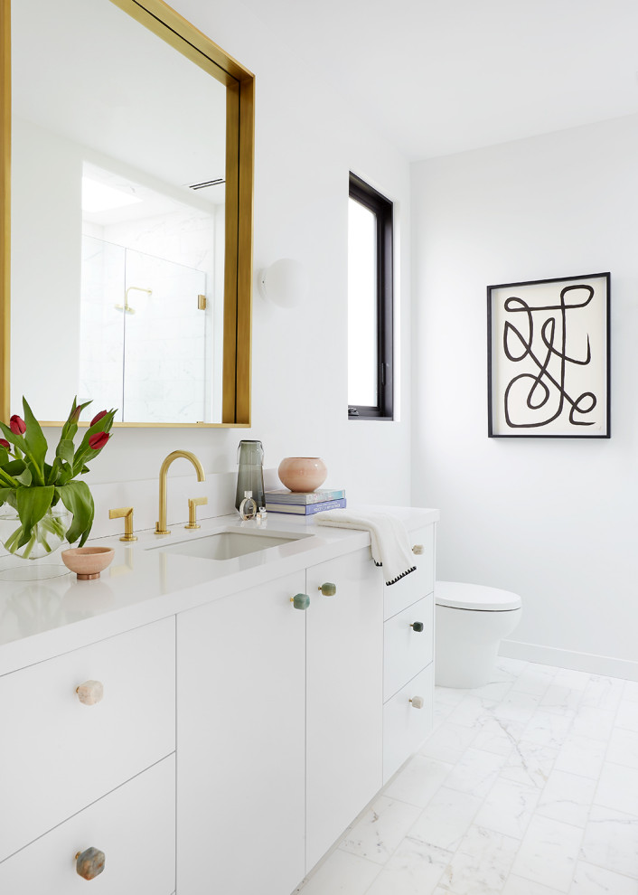 Inspiration for a mid-sized contemporary bathroom in Los Angeles with flat-panel cabinets, white cabinets, white walls, marble floors, white floor, white benchtops, a single vanity, a built-in vanity and an undermount sink.