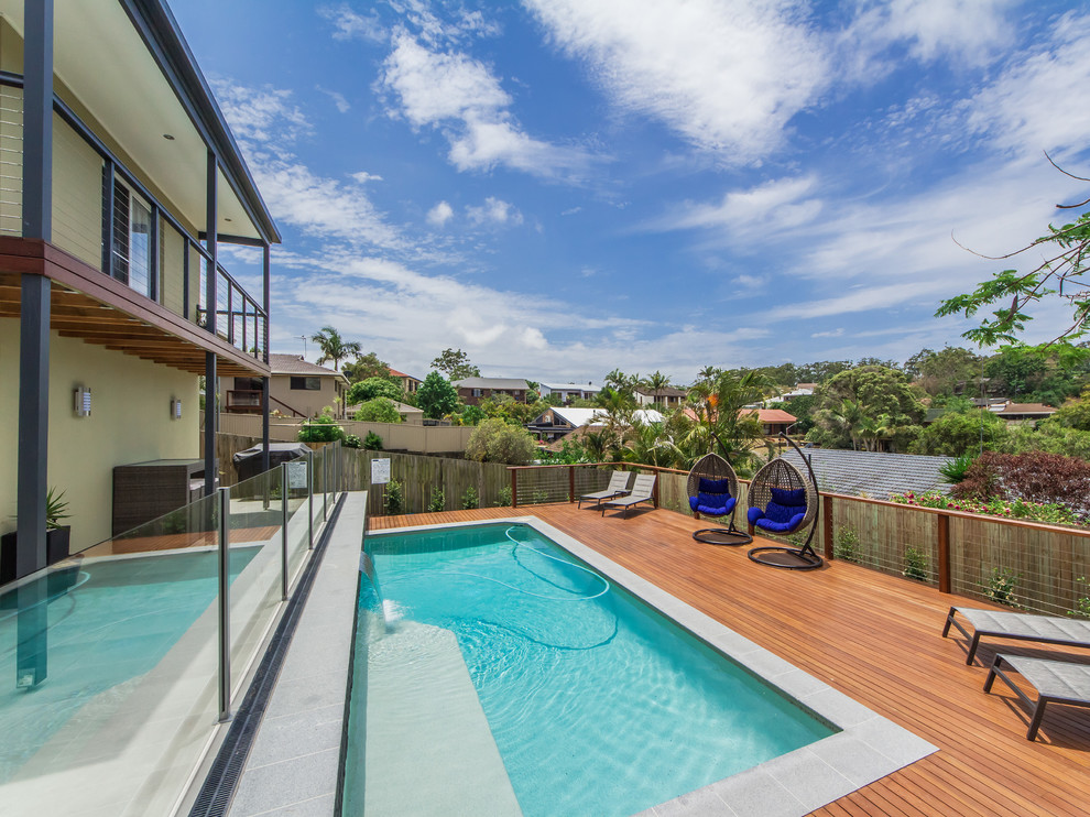 This is an example of a large contemporary backyard rectangular lap pool in Gold Coast - Tweed with a water feature and decking.