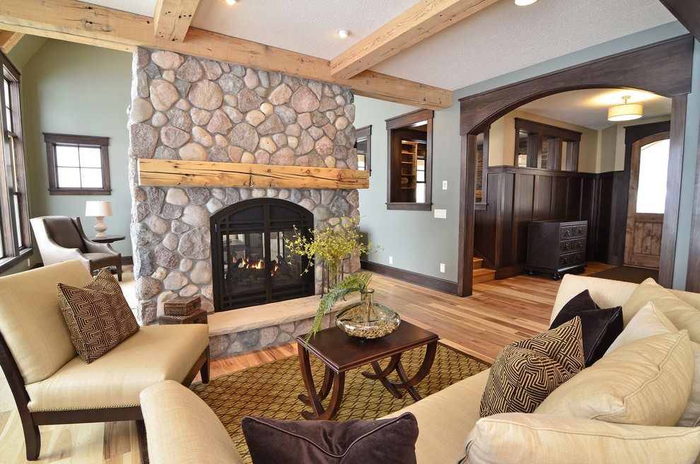 This is an example of a traditional living room in Minneapolis with green walls and a stone fireplace surround.