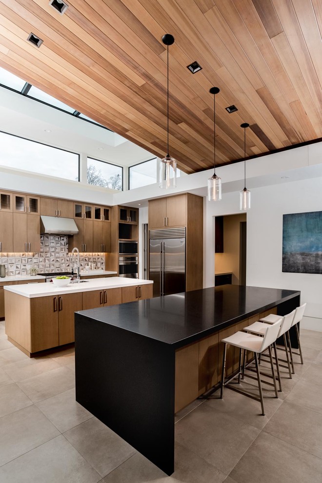 This is an example of a contemporary l-shaped open plan kitchen in San Francisco with flat-panel cabinets, medium wood cabinets, grey splashback, stainless steel appliances, multiple islands and grey floor.