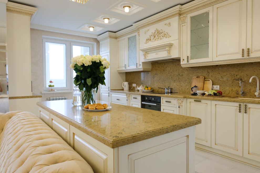 Inspiration for a large traditional galley open plan kitchen in Moscow with raised-panel cabinets, beige cabinets, quartz benchtops, brown splashback, marble splashback, black appliances, marble floors, with island, beige floor and brown benchtop.