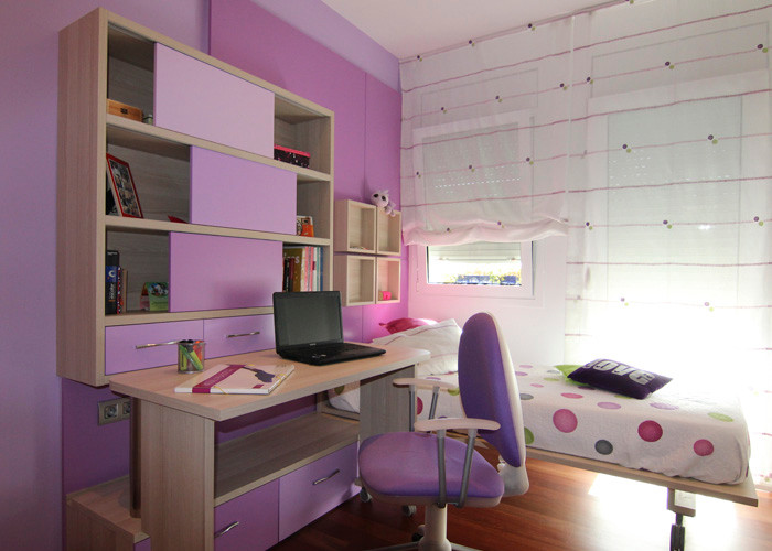 Mid-sized contemporary kids' room in Barcelona with dark hardwood floors and multi-coloured walls for girls.