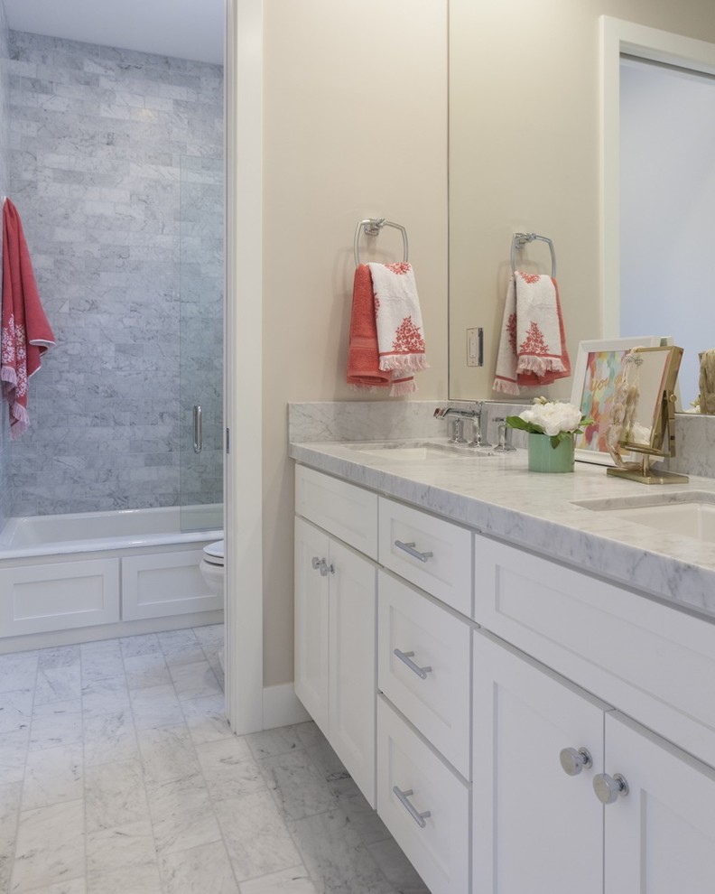 Photo of a mid-sized transitional 3/4 bathroom in Los Angeles with shaker cabinets, yellow cabinets, an alcove tub, a shower/bathtub combo, beige walls, marble floors, an undermount sink, marble benchtops, white floor and an open shower.