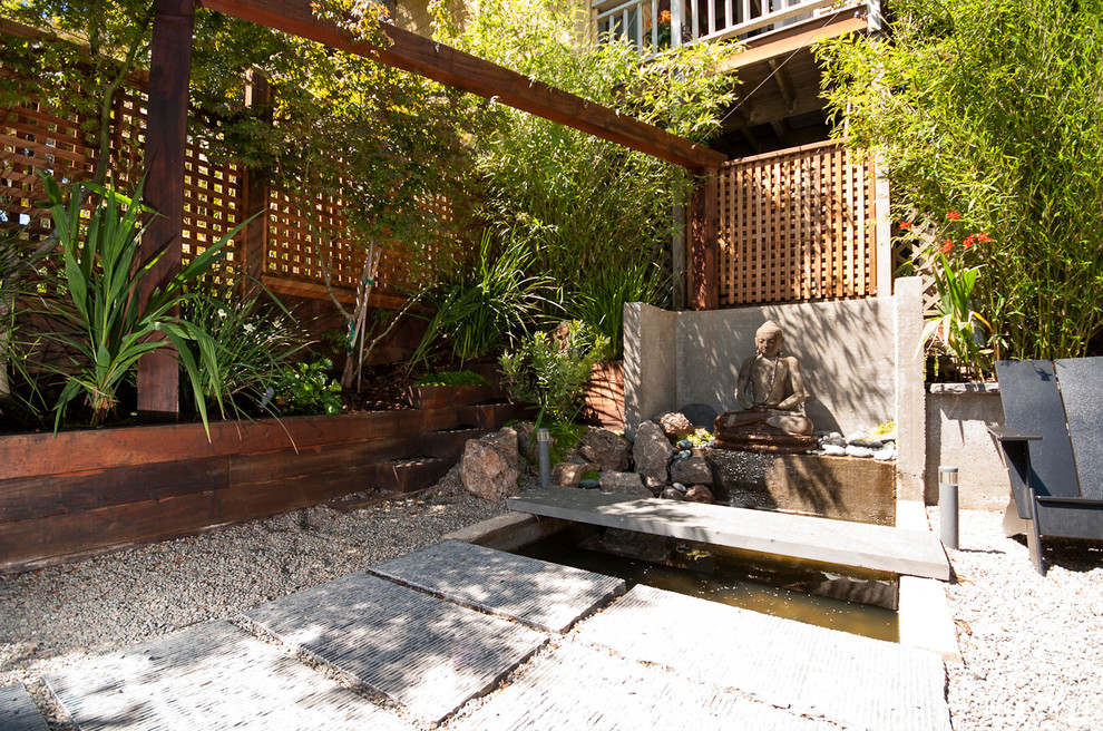 This is an example of a mid-sized asian courtyard partial sun garden in San Francisco with a water feature and gravel.