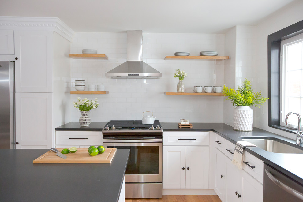 Inspiration for a small modern eat-in kitchen in Other with an undermount sink, shaker cabinets, white cabinets, granite benchtops, white splashback, subway tile splashback, stainless steel appliances, light hardwood floors, with island and brown floor.