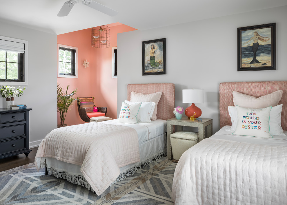 This is an example of a transitional kids' room for girls in New York with pink walls and dark hardwood floors.