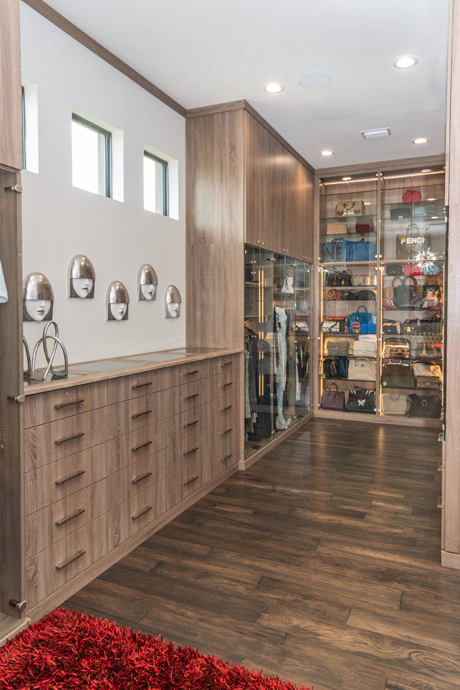 Inspiration for an expansive contemporary gender-neutral walk-in wardrobe in Tampa with glass-front cabinets, light wood cabinets, medium hardwood floors and brown floor.