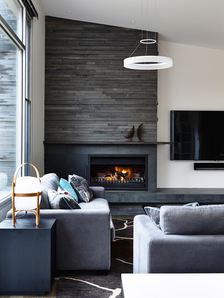 This is an example of a large transitional open concept living room in Melbourne with white walls, a corner fireplace, a stone fireplace surround, a wall-mounted tv and medium hardwood floors.