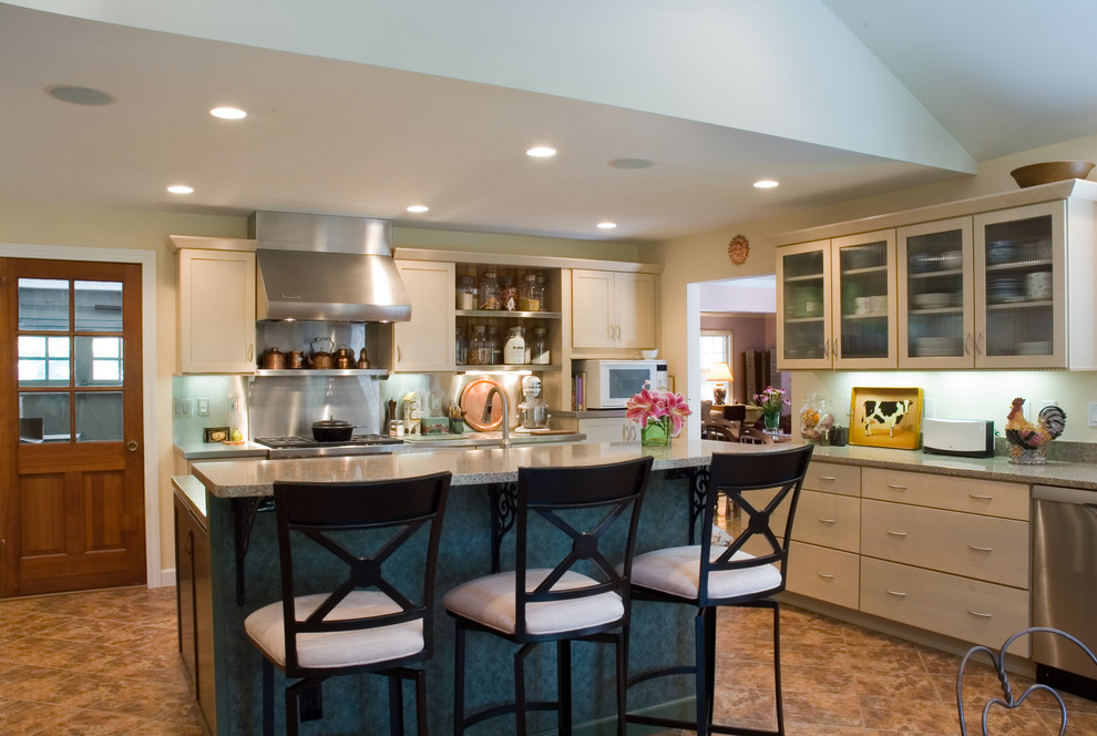 Eclectic kitchen in St Louis with stainless steel appliances, glass-front cabinets and beige cabinets.